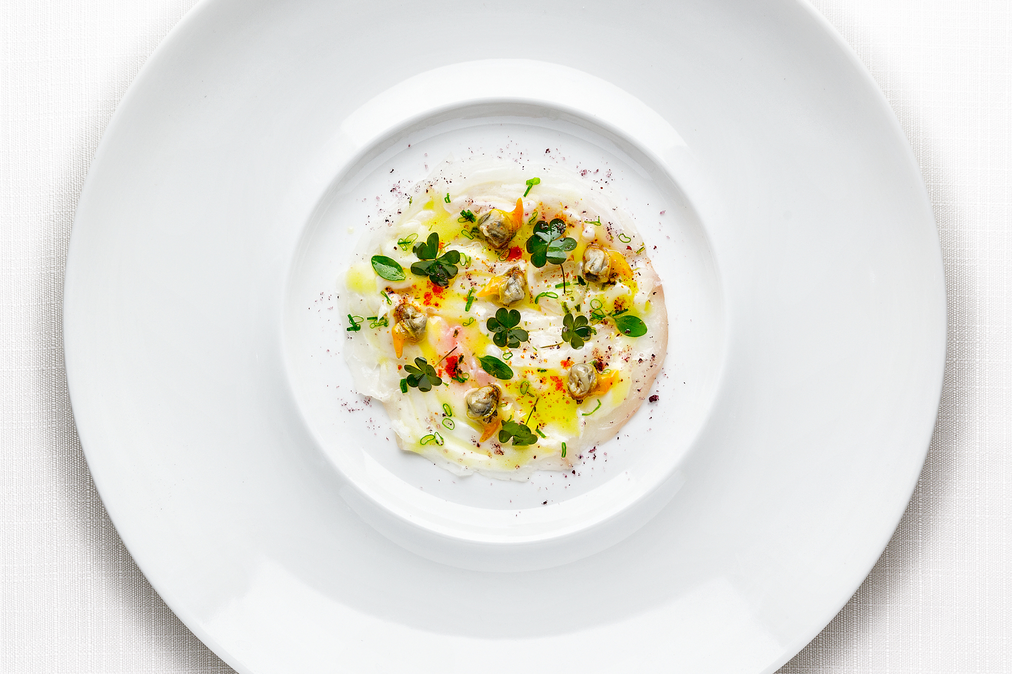 Carpaccio di dentice, vongole cuore Nieddittas e aromi orientali.