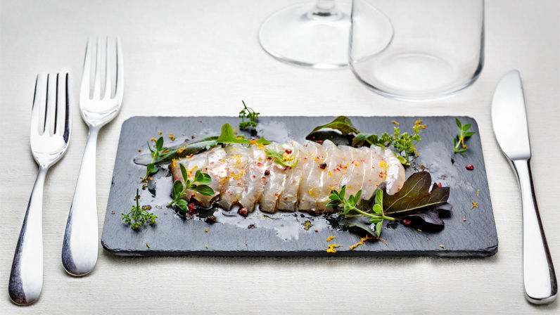 Carpaccio orata marinata agli agrumi e erbette, olio arancio mandorle